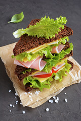 Sandwich with rye bread, ham, tomato, cheese and lettuce