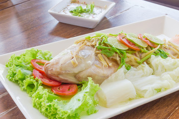 Steamed fish with chili and lemon on wood table , spicy food