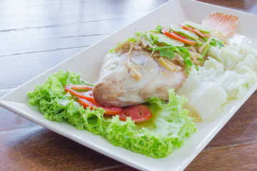 Steamed fish with chili and lemon on wood table , spicy food