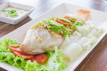 Steamed fish with chili and lemon on wood table , spicy food