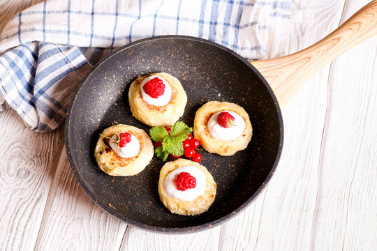 Cheese pancake, syrniki with raspberry in the pan