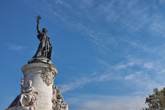 Statue de la R&eacute;publique. Place de la R&eacute;publique. Socle en pierre blanche. Ciel bleu. Paris, France.