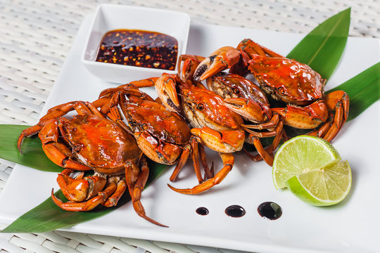 Cooked crab with sauce and lime on a plate
