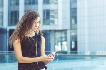 Curly girl typing message on smartphone