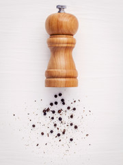 Close up of bottle black pepper mill on white wood table. Season