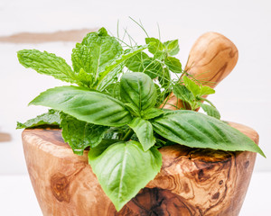 Alternative medicine fresh herbs in the wooden mortar . Food ing