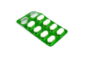 A white medicine in a green tablet on white background