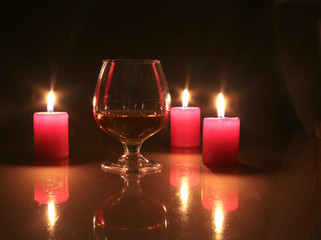 christmas photo cognac glass and candle on black background