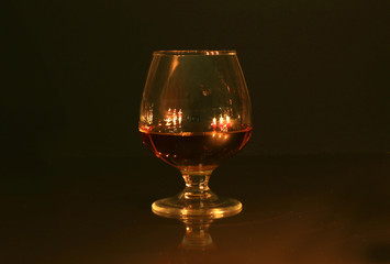 christmas photo cognac glass and candle on black background