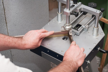 Craftsman working on frame in frame shop. Professional framer hand holding frame angle. Top view. Copy space. Top view