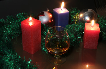 christmas photo cognac glass and candle on black background