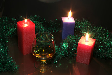 christmas photo cognac glass and candle on black background