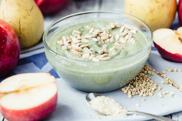 glass of smoothies with spirulina, apple and sunflower seeds