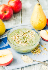 glass of smoothies with spirulina, apple and sunflower seeds