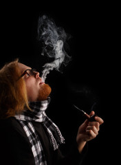 Obraz premium Man with red beard in chequered scarf and glasses holds tobacco