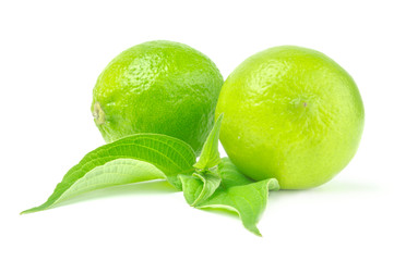 Two whole lime with leaves isolated on white