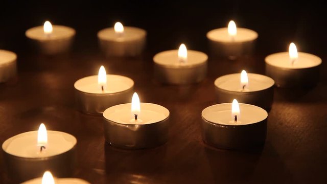 brennende Teelichter leuchten im Dunkeln