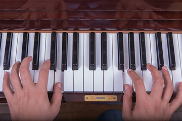 Man playing piano with both hands closeup