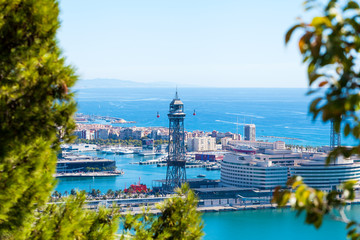 Fototapeta premium Cable car against the background of the city of Barcelona. View from Montjuic mountain to the city and Yacht port.