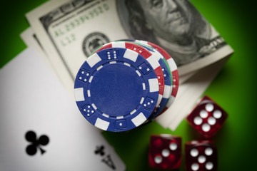 Poker chips, dices and playing cards on green table