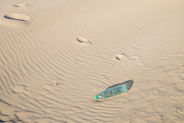 Empty plastic bottle on the sand