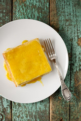 Imperfect square lemon cake and fork on white plate