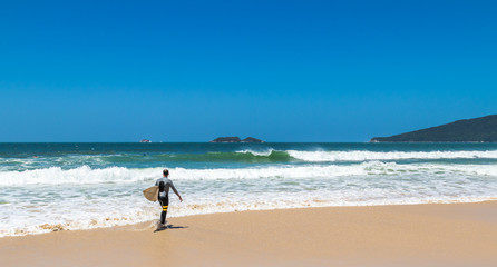 Surfista andando na praia.