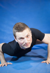 Fototapeta na wymiar Muscular young man exercising in his fitness gym; close-up (colo