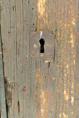 old keyhole of a ruined wooden door
