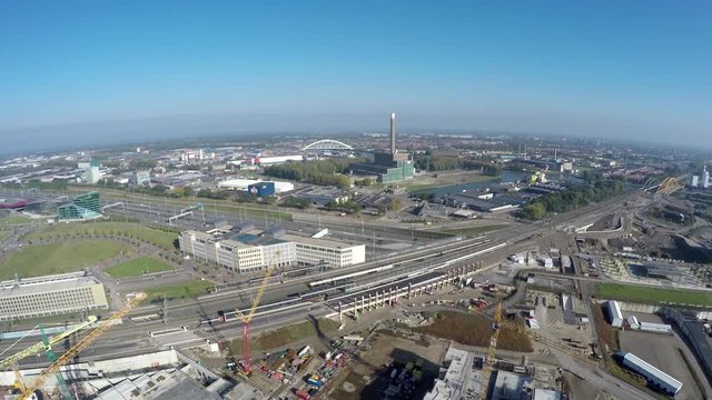 Aerial birds eye view of construction site drone moving backwards high overview showing large tall yellow tower cranes and underneath building site with the concrete foundation blue sky background 4k