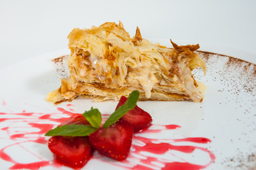 slice of decorated with strawberry napoleon cake, served on white plate