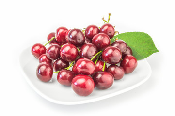 Fresh ripe cherries on a plate isolated   white background