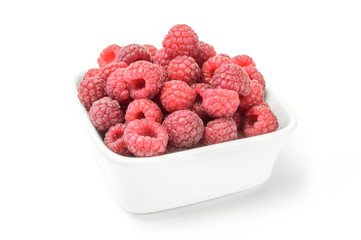 Raspberries on plate over white