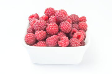 Fresh raspberries in a white bowl.