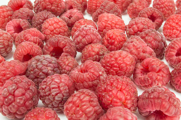 Fresh raspberries scattered on white background