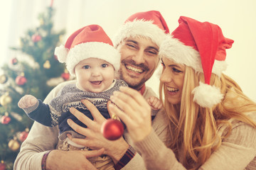 Happy family in the room with the Christmas tree