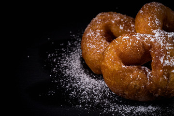 Sprinkling sugar powder on donut
