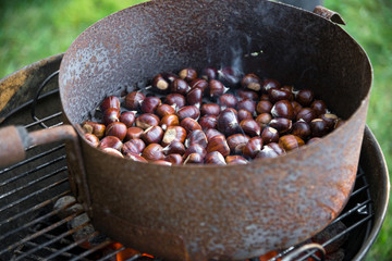 Maroni braten in einer Maronipfanne über offenem Feuer
