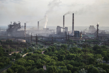 Industrial landscape in Ukraine. Steel factory with smog at sunset. Pipes with smoke. Metallurgical plant. steelworks, iron works. Heavy industry. Ecology problems, atmospheric pollutants.