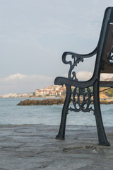 Empty wrought iron bench a deserted promenade overlooking the sea 