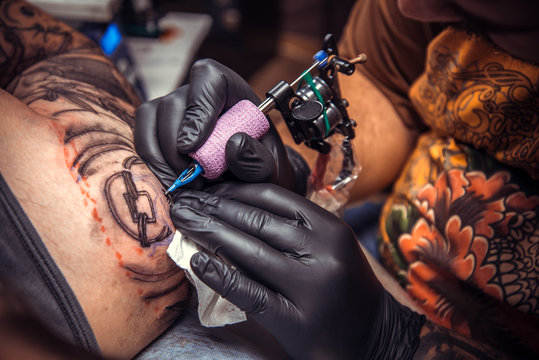Professional tattoo artist doing tattoo in tattoo studio