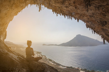 Fototapeta na wymiar Woman meditating against view of Telendos Island at sunset. Kaly