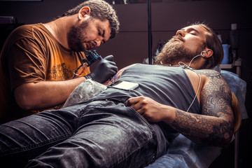 Tattooer working tattooing in studio