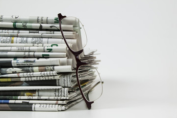 Zeitungsstapel mit Lesebrille