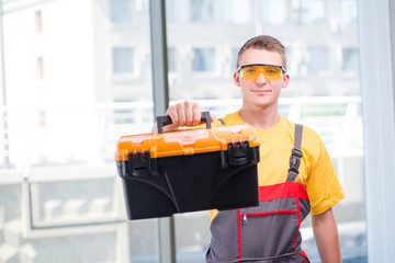 Young construction worker in yellow coveralls