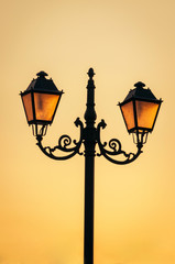 Fototapeta na wymiar Glowing street lamps/lanterns on a sunset sky