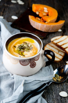 Creamy pumpkin cream soup with pumpkin sunflower seeds and olive oil

