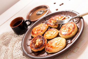 Cottage cheese pancakes with honey on brown ceramic plate
