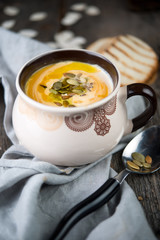 Creamy pumpkin cream soup with pumpkin sunflower seeds and olive oil
