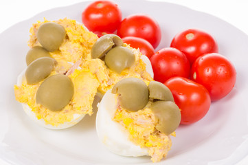 stuffed eggs and red little tomatoes on a pot